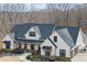 Beautiful white farmhouse with dark roof, black windows, and manicured landscaping at 8710 Little Mill Rd, Cumming, GA 30041