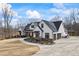 Stunning white farmhouse with a three-car garage, complemented by lush landscaping at 8710 Little Mill Rd, Cumming, GA 30041