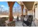 Covered front porch with wooden columns, rocking chairs, and landscaped front yard at 8710 Little Mill Rd, Cumming, GA 30041