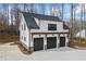 Three car garage with black doors and a white frame at 8710 Little Mill Rd, Cumming, GA 30041