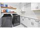 Functional laundry room with modern appliances, ample counter space, and floating shelves for storage at 8710 Little Mill Rd, Cumming, GA 30041