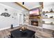 Comfortable living room boasts a brick fireplace and mantle with floating wood shelves and modern decor at 8710 Little Mill Rd, Cumming, GA 30041