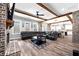 Open concept living room flows to the kitchen and features exposed wood beams, a fireplace, and a large sectional at 8710 Little Mill Rd, Cumming, GA 30041