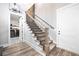 Bright staircase with wooden handrail, iron balusters, and access to the laundry room at 8710 Little Mill Rd, Cumming, GA 30041