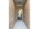 Exterior view of the front door surrounded by brick on a covered portion of the front porch at 2677 Pearl Ridge Trce, Buford, GA 30519