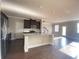 Open kitchen with a granite island, stainless steel appliances and dark wood floors at 2677 Pearl Ridge Trce, Buford, GA 30519