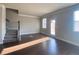 Bright living room with hardwood floors, stairs, and natural light coming from a large window at 2677 Pearl Ridge Trce, Buford, GA 30519