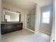 Main bathroom featuring granite top double vanity, large framed mirror, and a glass shower door at 2677 Pearl Ridge Trce, Buford, GA 30519