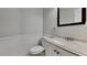 Powder bathroom featuring white wainscoting, light speckled countertop, and wood-framed mirror at 8541 Glendevon Ct, Riverdale, GA 30274