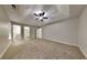 A spacious main bedroom with a ceiling fan, carpeted floor, and attached closet at 8541 Glendevon Ct, Riverdale, GA 30274
