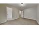 A simple bedroom with a carpeted floor, attached closet, and light-colored walls at 8541 Glendevon Ct, Riverdale, GA 30274