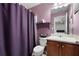 Cozy bathroom with a purple shower curtain, a vanity with a sink, and tile flooring at 1227 Castle Point Sw Ct, Conyers, GA 30094