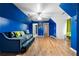 Bright bedroom with hardwood floors, a vibrant blue accent wall, and ample natural light at 1227 Castle Point Sw Ct, Conyers, GA 30094