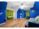 Spacious bedroom with hardwood floors, a vibrant blue accent wall, and ample natural light at 1227 Castle Point Sw Ct, Conyers, GA 30094