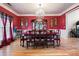 Formal dining room features red walls, chandelier, and hardwood floors at 1227 Castle Point Sw Ct, Conyers, GA 30094