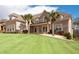 Beautiful two-story brick home with a lush green lawn and palm trees, offering great curb appeal at 1227 Castle Point Sw Ct, Conyers, GA 30094