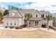 Charming two-story brick home featuring a well-manicured lawn and beautiful landscaping, including palm trees at 1227 Castle Point Sw Ct, Conyers, GA 30094