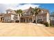 Beautiful two-story brick home with a lush green lawn and palm trees, offering great curb appeal at 1227 Castle Point Sw Ct, Conyers, GA 30094
