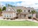 Charming two-story brick home featuring a well-manicured lawn and beautiful landscaping, including palm trees at 1227 Castle Point Sw Ct, Conyers, GA 30094