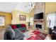Inviting living room with brick fireplace, mounted TV, hardwood floors, high ceilings, and comfortable sofa at 1227 Castle Point Sw Ct, Conyers, GA 30094