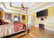 Spacious main bedroom with trey ceiling, hardwood floors, decorative ceiling fan and private ensuite bathroom at 1227 Castle Point Sw Ct, Conyers, GA 30094