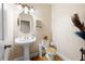 Charming powder room features pedestal sink, decorative mirror, and stylish fixtures at 1227 Castle Point Sw Ct, Conyers, GA 30094