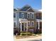 Charming townhouse with a mix of stone and blue siding, featuring a covered porch and well-maintained landscaping at 2316 Limehurst Ne Dr, Atlanta, GA 30319