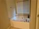 Corner bathtub under window with blinds in a neutral-toned bathroom at 114 Crescent Woode Way, Dallas, GA 30157
