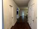 A hallway with hardwood floors leads to an open living area and kitchen at 114 Crescent Woode Way, Dallas, GA 30157