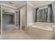 Spacious bathroom with tile floors, a soaking tub, a walk-in closet, and lots of natural light at 624 Longbow Ct, Stone Mountain, GA 30087