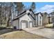 View of the garage and driveway, featuring stucco siding, and blue trim at 624 Longbow Ct, Stone Mountain, GA 30087