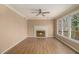 Cozy living room with fireplace, ceiling fan, and an abundance of natural light from large windows at 624 Longbow Ct, Stone Mountain, GA 30087