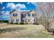 Charming brick two-story home with a well-maintained lawn and mature trees against a beautiful blue sky at 85 Tanglewood Dr, Covington, GA 30016