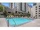 Sparkling pool with ample lounge chairs, surrounded by lush greenery and cityscape views at 275 13Th St # Apt 509, Atlanta, GA 30309