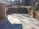 Cement patio in backyard with partial brick walls and foliage at 2329 Crestknoll Cir, Decatur, GA 30032