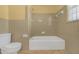 Bathroom featuring tiled walls, tub and toilet, and a window for natural light at 2329 Crestknoll Cir, Decatur, GA 30032