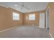 Spacious bedroom featuring neutral carpet, two windows with blinds, ceiling fan, and white trim throughout at 2329 Crestknoll Cir, Decatur, GA 30032