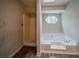 Dated bathroom boasts a soaking tub with a window view and separate shower stall at 3500 Quail Hollow Trl, Snellville, GA 30039
