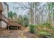 Backyard featuring a wooden deck with stairs leading down to a wooded lot that backs up to trees at 4570 Thicket Trl, Snellville, GA 30039