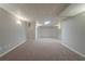 A finished basement with neutral carpet, light gray walls, and unique lighting at 4570 Thicket Trl, Snellville, GA 30039