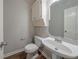 This powder room features wood look floors, toilet, pedestal sink and single vanity at 4570 Thicket Trl, Snellville, GA 30039