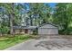 Charming home with stone accents, gray siding, red front door, attached garage and mature trees at 1408 Fairfield Sw Dr, Lilburn, GA 30047