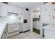 Cozy kitchen featuring white appliances, cabinets, and views into the laundry area at 2 Westchester Sq, Decatur, GA 30030