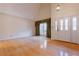 Spacious living room with wood floors, tall ceilings, a window with curtains, and a double door entrance at 2 Westchester Sq, Decatur, GA 30030