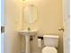 Half-bathroom features a pedestal sink, toilet, mirror, and brass fixtures at 1399 Dukes Creek Nw Dr, Kennesaw, GA 30152