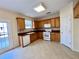 Well-lit kitchen with wooden cabinets, a white dishwasher and a white range at 1399 Dukes Creek Nw Dr, Kennesaw, GA 30152