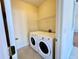 Convenient laundry room with a full-size washer and dryer and overhead shelving at 1399 Dukes Creek Nw Dr, Kennesaw, GA 30152