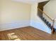 Sunlit living room featuring wood floors and classic wainscoting, adjacent to the stairs at 1399 Dukes Creek Nw Dr, Kennesaw, GA 30152