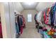 Spacious walk-in closet with carpeted floor and plenty of hanging storage, with a window for natural light at 1960 Overlook Springs Ln, Cumming, GA 30040