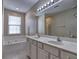 Bathroom with double vanity, soaking tub, and large mirror at 2357 Barrett Cottage Pl, Marietta, GA 30066